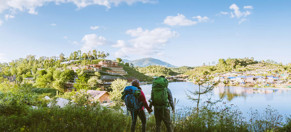 Rear view of woman walking on mountain against sky