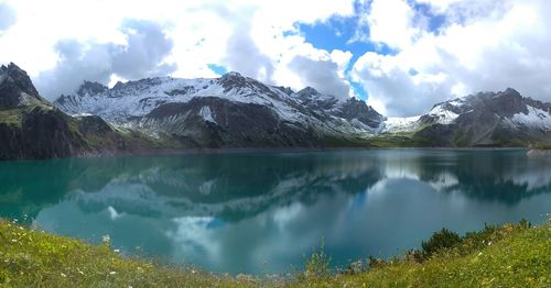 Panoramic view of lake with snowcapped mountain range in background