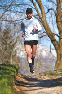 Young man running athlete during a workout in a hill