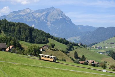 High angle view of people walking on field against mountains