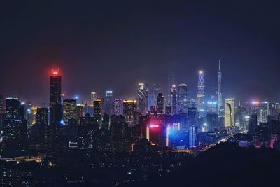 Illuminated cityscape against sky at night