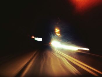 Light trails on road in tunnel at night