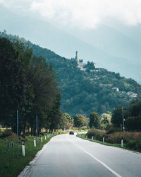 Road amidst trees against sky