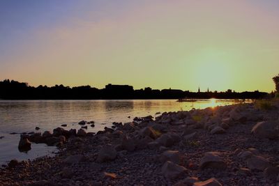 Scenic view of lake against clear sky at sunset