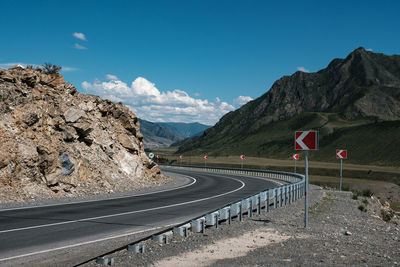 Road leading towards mountains against sky