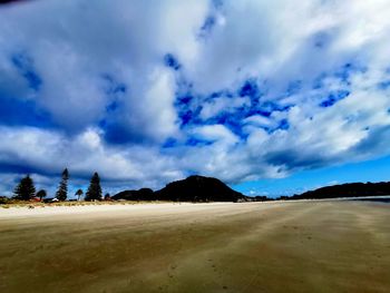 Scenic view of beach against blue sky