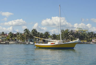 Sailboats moored on sea against sky