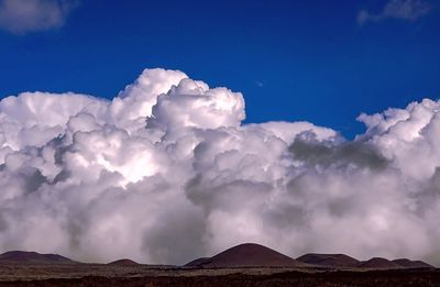 Scenic view of mountains against blue sky