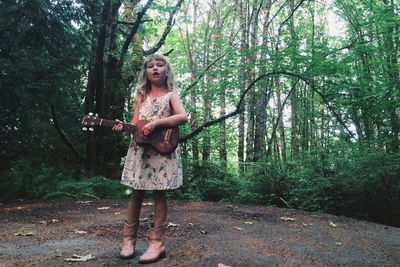 Portrait of young woman standing in forest