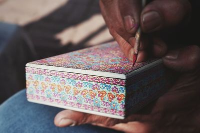 Cropped image of person painting box