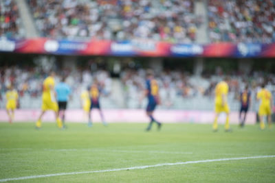 Soccer players playing on field in stadium