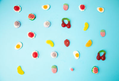 High angle view of multi colored candies against blue background