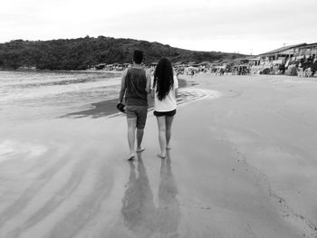 Rear view of friends walking on land