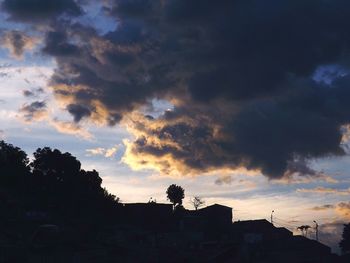 Silhouette of trees against cloudy sky