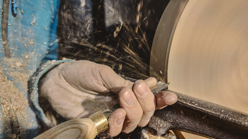 Midsection of craftsperson working in workshop