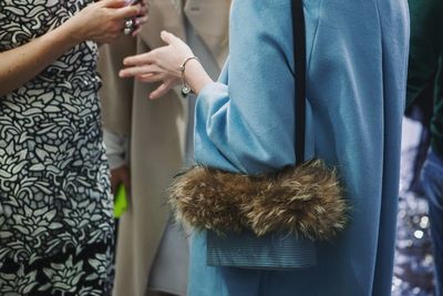 Midsection of women talking while standing outdoors