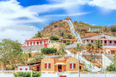 Low angle view of houses on mountain against sky