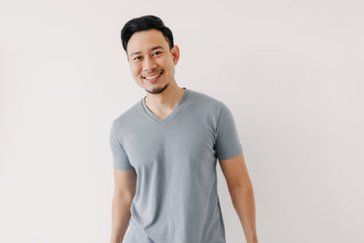 Portrait of smiling young man against white background