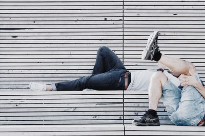 Low section of friends sleeping on floor outdoors
