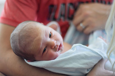 Mother carrying cute baby girl at home