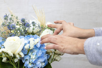 Cropped hands of florist decorating bouquet in flower shop