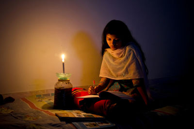 Woman studying with open book in darkroom