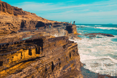 Rock formation on beach against sky