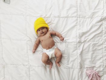 High angle view of baby girl lying on bed