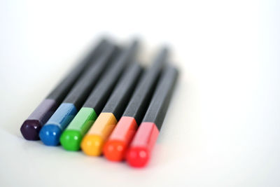 Close-up of colored pencils over white background