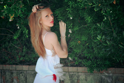 Portrait of woman standing by plants