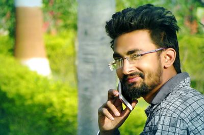 Portrait of smiling young man talking on mobile phone