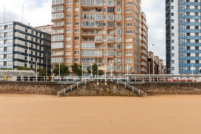 Low angle view of buildings by the beach against sky