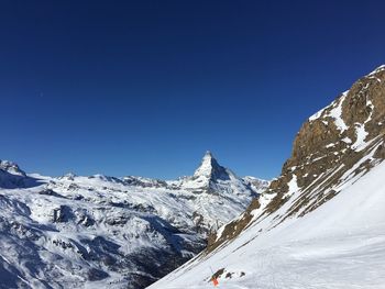 Scenic view of snowcapped mountains against clear blue sky