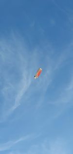 Low angle view of kite flying against blue sky