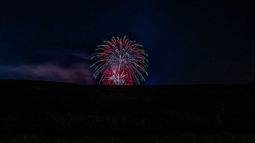 Low angle view of firework display at night