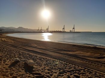 Scenic view of beach against clear sky during sunset