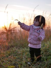 Full length of girl in grass during sunset