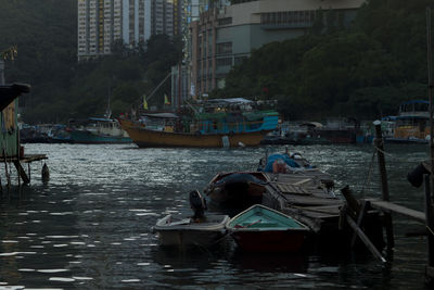 Fishing boats moored at harbor in city