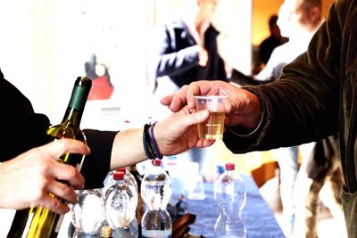 Person offering drink to customer at bar