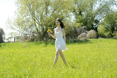 Rear view of woman standing on grassy field