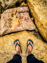 Low section of man standing on rock