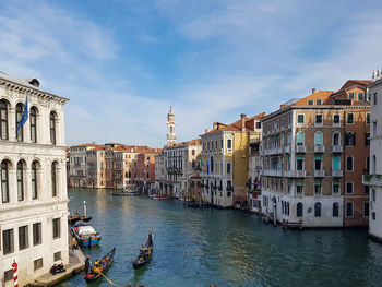 Boats in canal amidst buildings in city