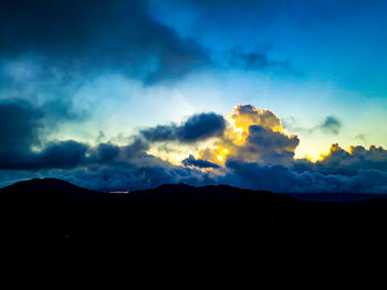 Low angle view of silhouette mountain against dramatic sky