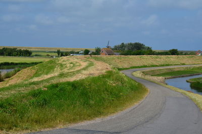 Scenic view of grassy field against cloudy sky