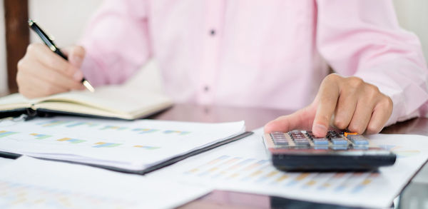 Midsection of businessman working at desk in office