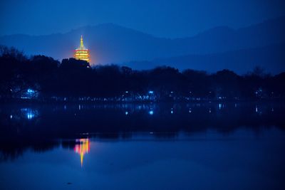 Reflection of illuminated building in lake at night