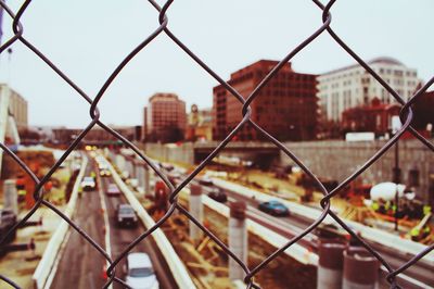 Road and buildings seen through chainlink fence