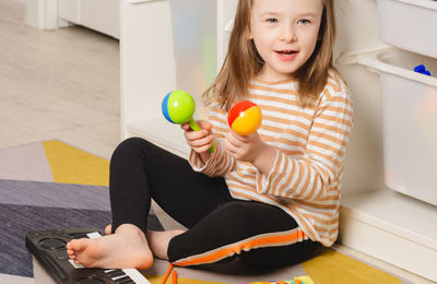 Child playing maracas at home. leisure and education at home