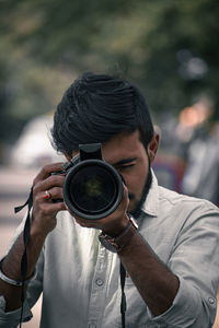 Young man photographing through camera