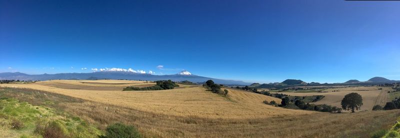 Panoramic view of landscape against clear blue sky